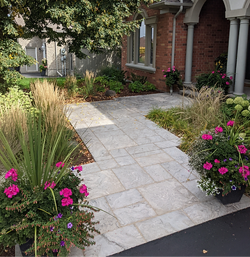 Natural stone front walkway with established native gardens