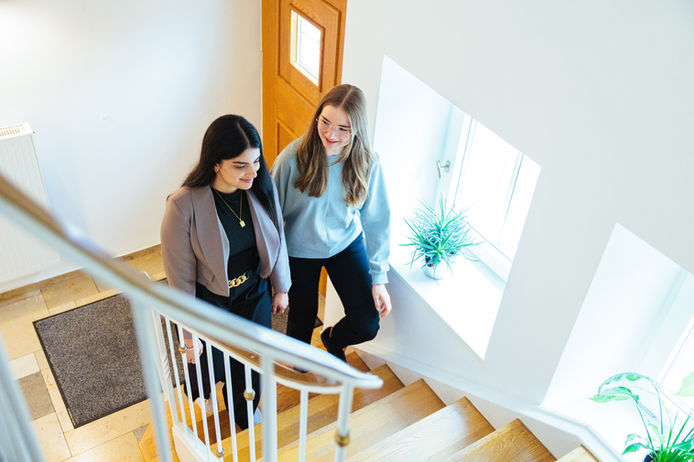 Zwei Mitarbeitende laufen die Treppe hinauf
