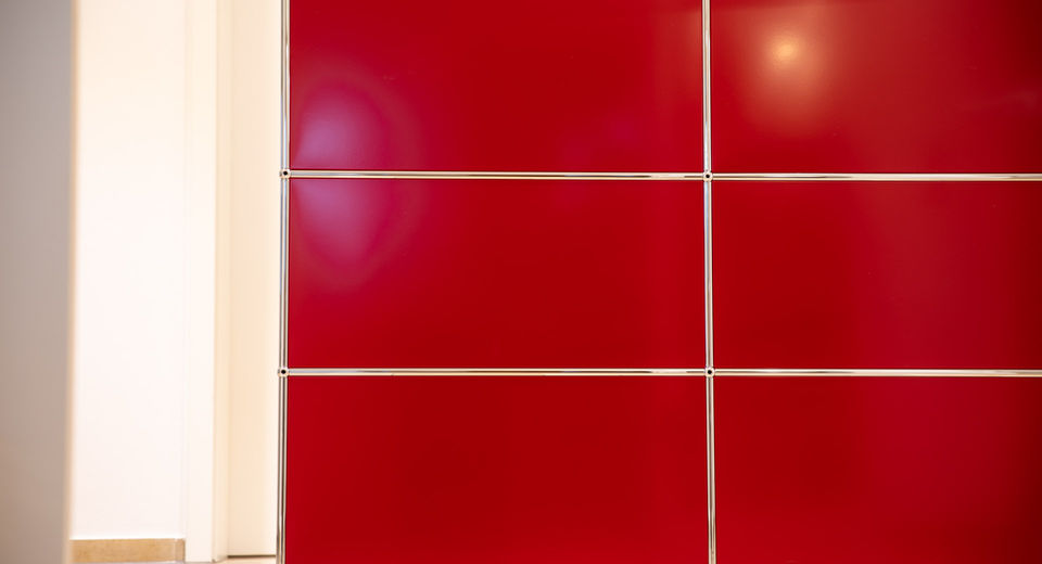 Rote Schranktüren mit silbernen Linien, Teil einer modernen Wohnungsdekoration.