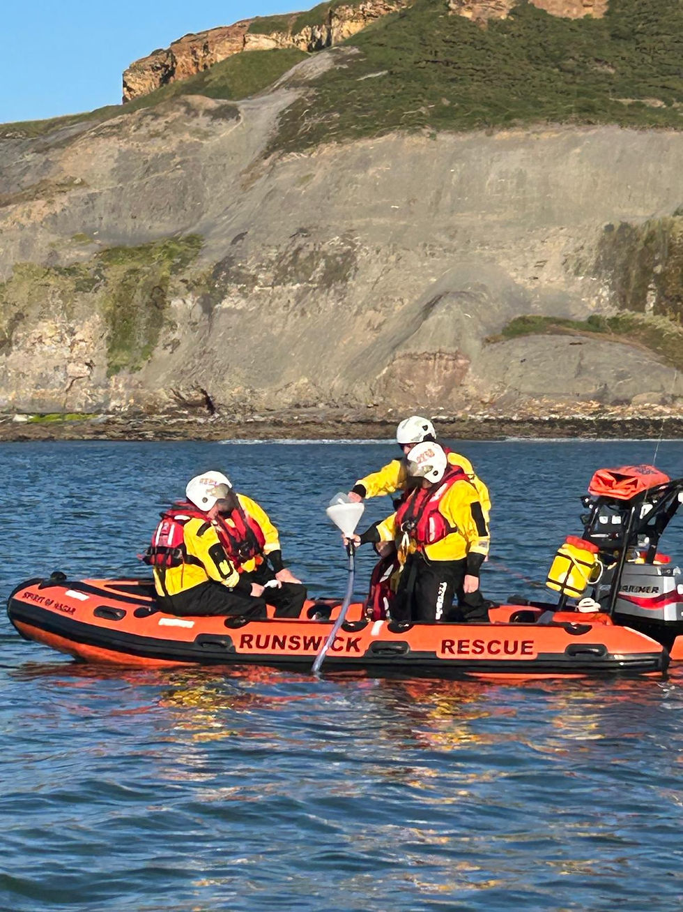 High angle view of Runswick Bay coastline with rescue boat returning after lobster release