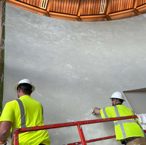Plaster mike and a co-worker on a scissor lift applying decorative plaster on a 30ft wall in Kansas City