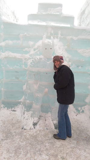 Jaime in a black jacket posing by a large ice sculpture