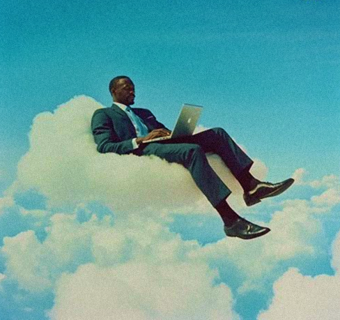 Man in a dark blue suit using a laptop while floating on a cloud, with a light blue sky in the background. A surreal and symbolic scene of borderless digital work.