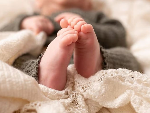 Gros plan des pieds d’un nouveau-né en studio à Villefranche-sur-Saône, séance réalisée par Lucy Cast