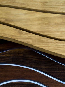 Wavy patterns in light and dark wood, close up of tables as part of hand made nature inspired furniture