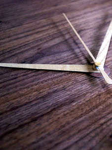 wood clock hands on a wooden surface