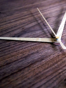 wood clock hands on a wooden surface