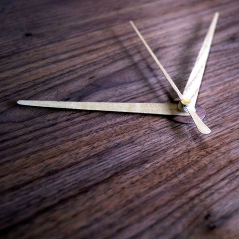 wood clock hands on a wooden surface