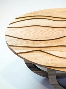 Wooden table with carved wavy lines as part of hand made nature inspired furniture