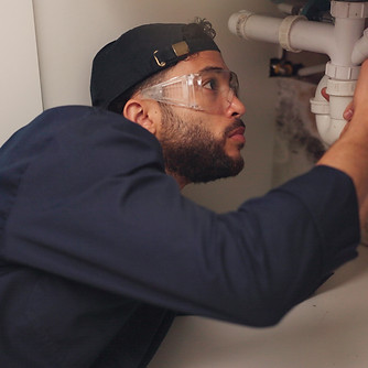 image of a plumber fixing a pipe