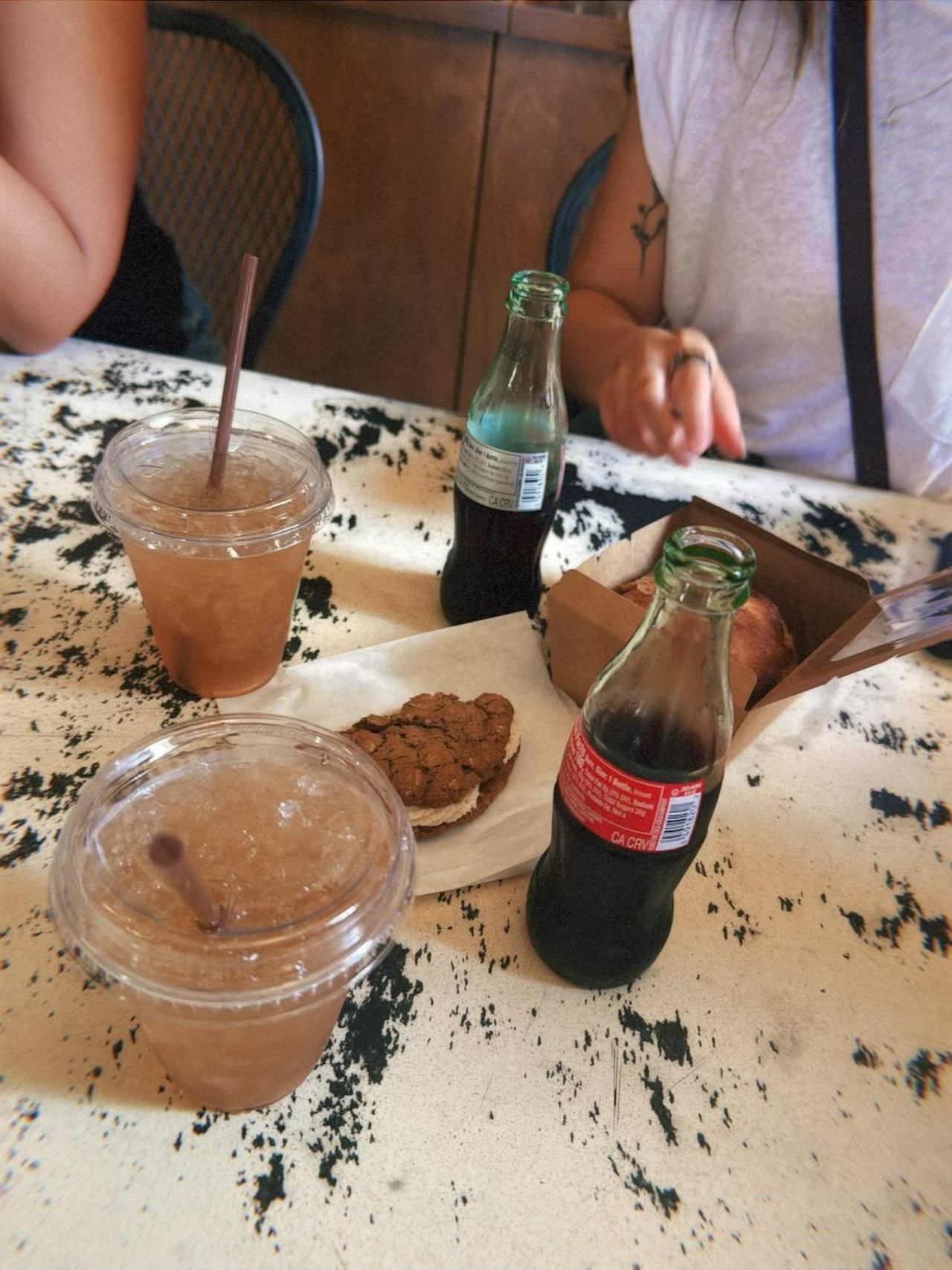 Iced drinks, cookies, and bottled soda on a café table at The Pharmacy on Main in Fredericksburg, Texas.