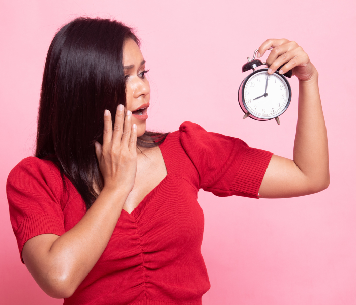 woman holding clock and worried about time