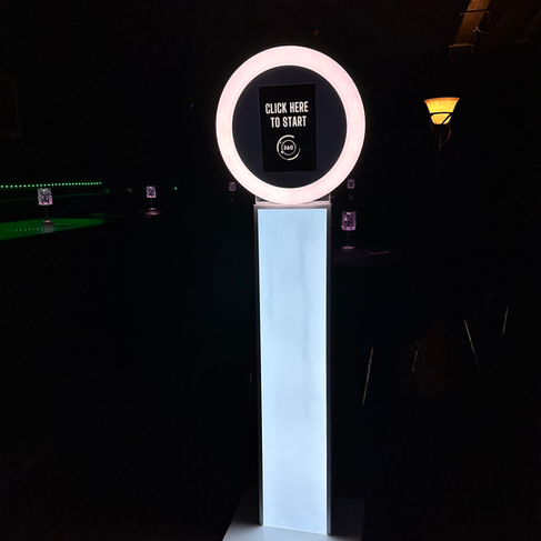 A Selfie Pod Photo Booth lit up in a  dark room ready for a corporate event. Supplied by 360 Photo Hire.