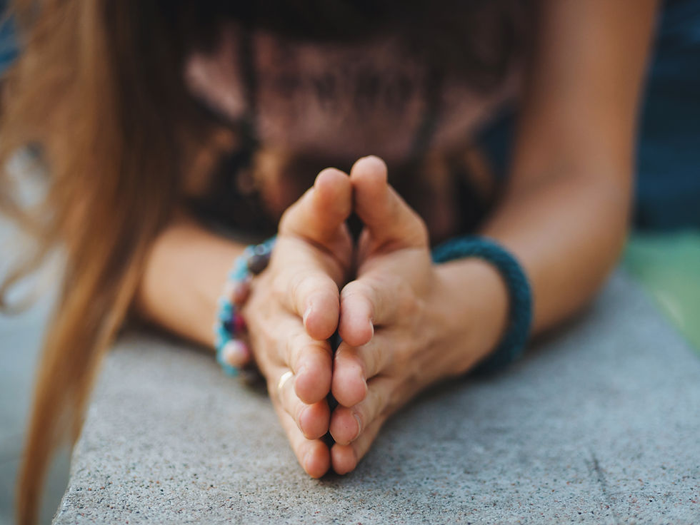 Women's hands with palms pressed together in Anjali Mudra position signifies connection to self and is a common gesture in yoga and meditation as a symbol of respect and reverence.
