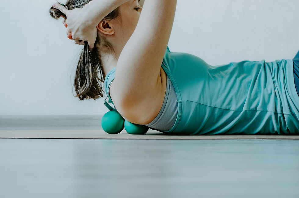 A woman uses therapy balls to release tension in the upper back, applying gentle pressure to alleviate muscle tightness and adhesions.