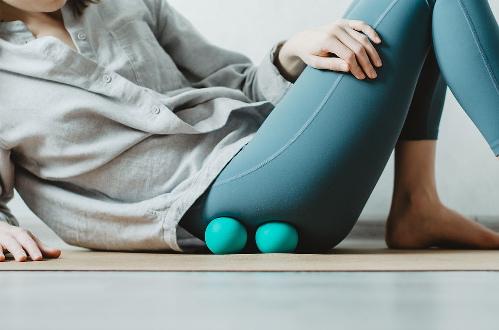 Woman practicing self-massage with two therapy balls targeting the fascia around the gluteus muscles of the hip with sinking pressure, calming the nervous system and improving local circulation.
