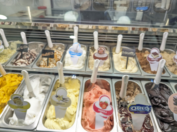 A gelateria showing tubs of different flavours of icecream.