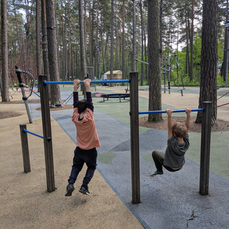 2 boys swinging on bars in Dzintari Playground