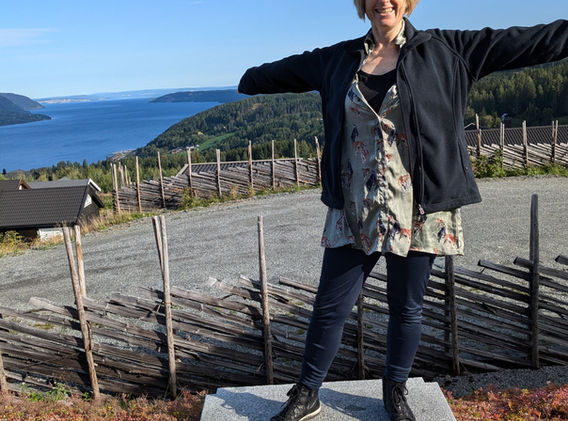 Woman enjoying the sun and view of lake from decking