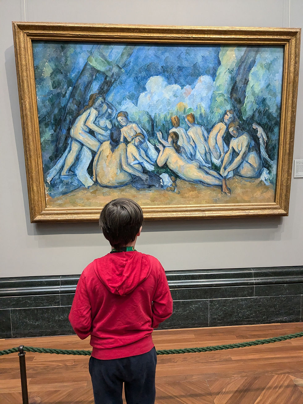 An autistic child stands in the National Gallery London looking at a painting by the artist Cezanne