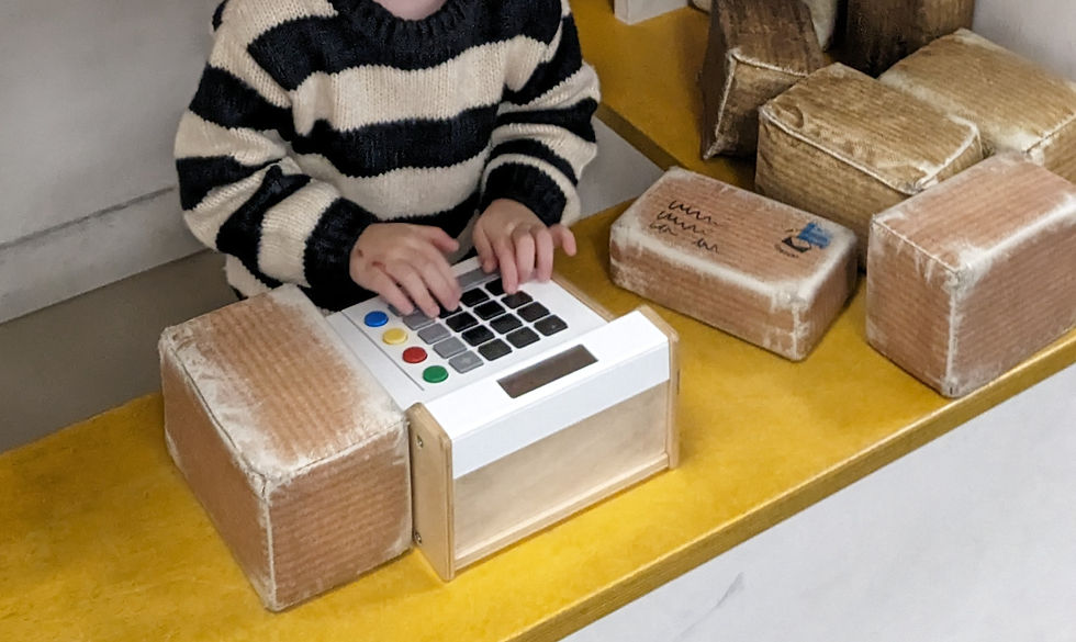 Autistic child enjoying role playing as a post mistress selling postage in a toy post office - SORTED! play space, The postal Museum, London