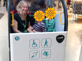 Mum and autistic children in the back of an airport assistance transfer buggy at heathrow