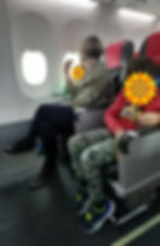A mother and two autistic children sit in a plane