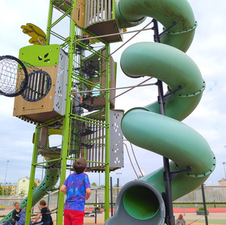 A boy looking up at the giant spiral lide in Riga Centre Sports Park