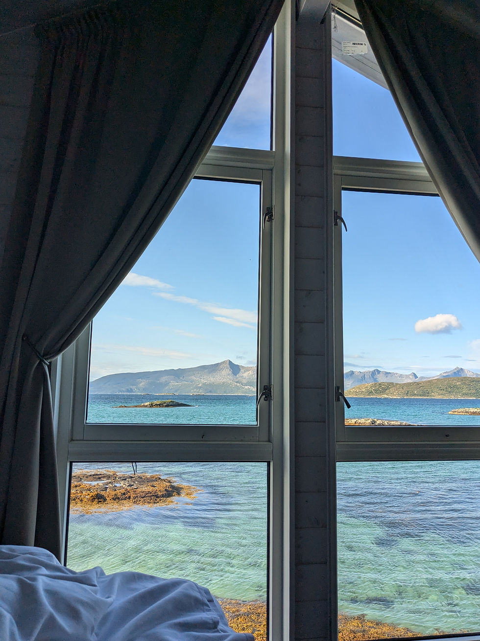 View of turquoise seas surrounding Sommaroy island, looking out from the author's bedroom window in an apartment at the Arctic hotel, Norway