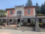 Exterior of Stazione Terme Restaurant, San Pellegrino, Lombardy Italy. Steps leading pu to grand entrance with shaded awnings either side.
