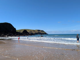 Hope Cove beach, crashing waves and sea cliffs.