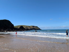 Hope Cove beach, crashing waves and sea cliffs.