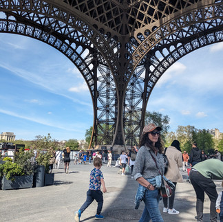 An autistic child running through the space beneath the Eiffel Tower