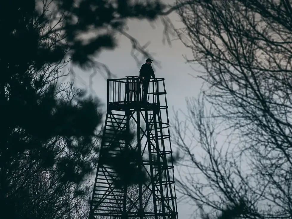 Person on a lookout tower in the Jeffery Shockley writing portfolio.