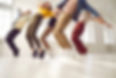 Dancers in colourful clothes dancing in a studio and posing on their toes