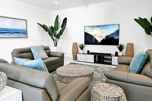 Living room in modern Luxury Villa for vacation rental in Providenciales, Turks & Caicios, surrounded by lush tropical greenery, turquoise water and white sand beach 