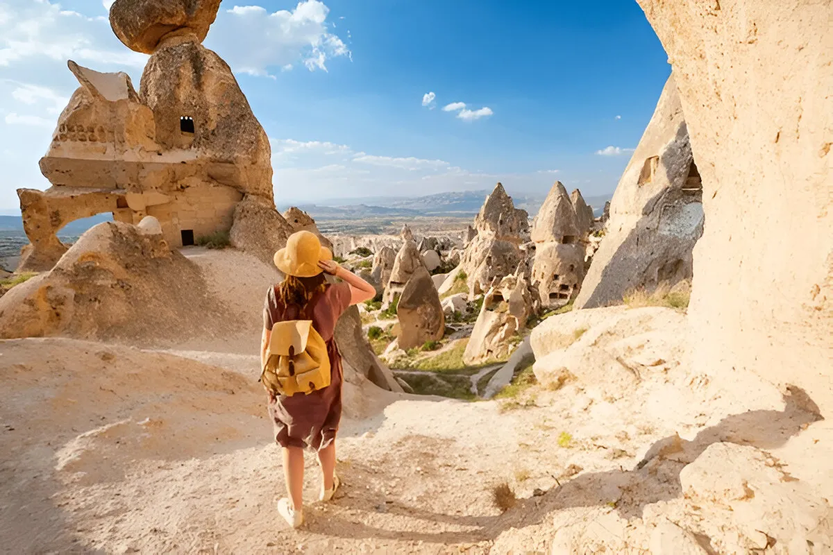 A curious female traveler explores Cappadocia’s fairy chimneys and valleys, imagining their formation and the lives of ancient people."