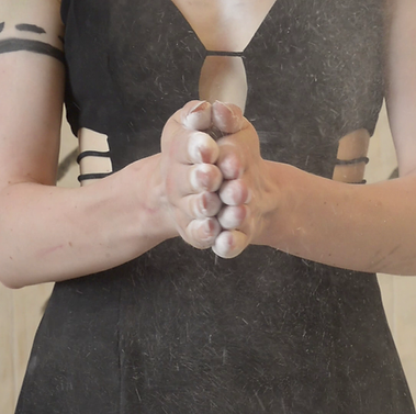 Dancer posing with hands together, a project that's coming soon.