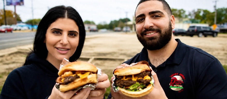 Hesham and Sara of Roul's Deli holding signature menu items outside their family-owned Louisiana restaurant