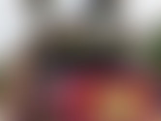 Rose Parade float at FloatFest featuring a train decorated with colorful flowers and natural plant materials.