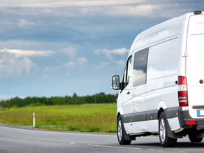 Weißer Transporter auf Landstraße bei Tageslicht – Symbolbild für studentische Transportermiete bei Europcar mit 15 % Rabatt.