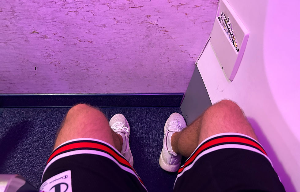 Beinfreiheit auf Sitzplatz 1F bei Ryanair mit direktem Blick auf die vordere Kabinenwand unter violetter Ambientebeleuchtung.