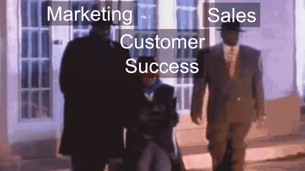 A gif from the Geto Boy's music video "Damn, it feels good to be a gangsta". It shows the 3 characters walking for 5 seconds with "marketing", "customer success", and "sales" words floating over their heads.