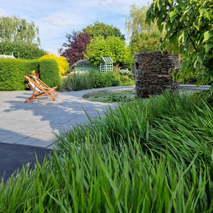 hakonechloa grass in foreground of pond and stone water feature