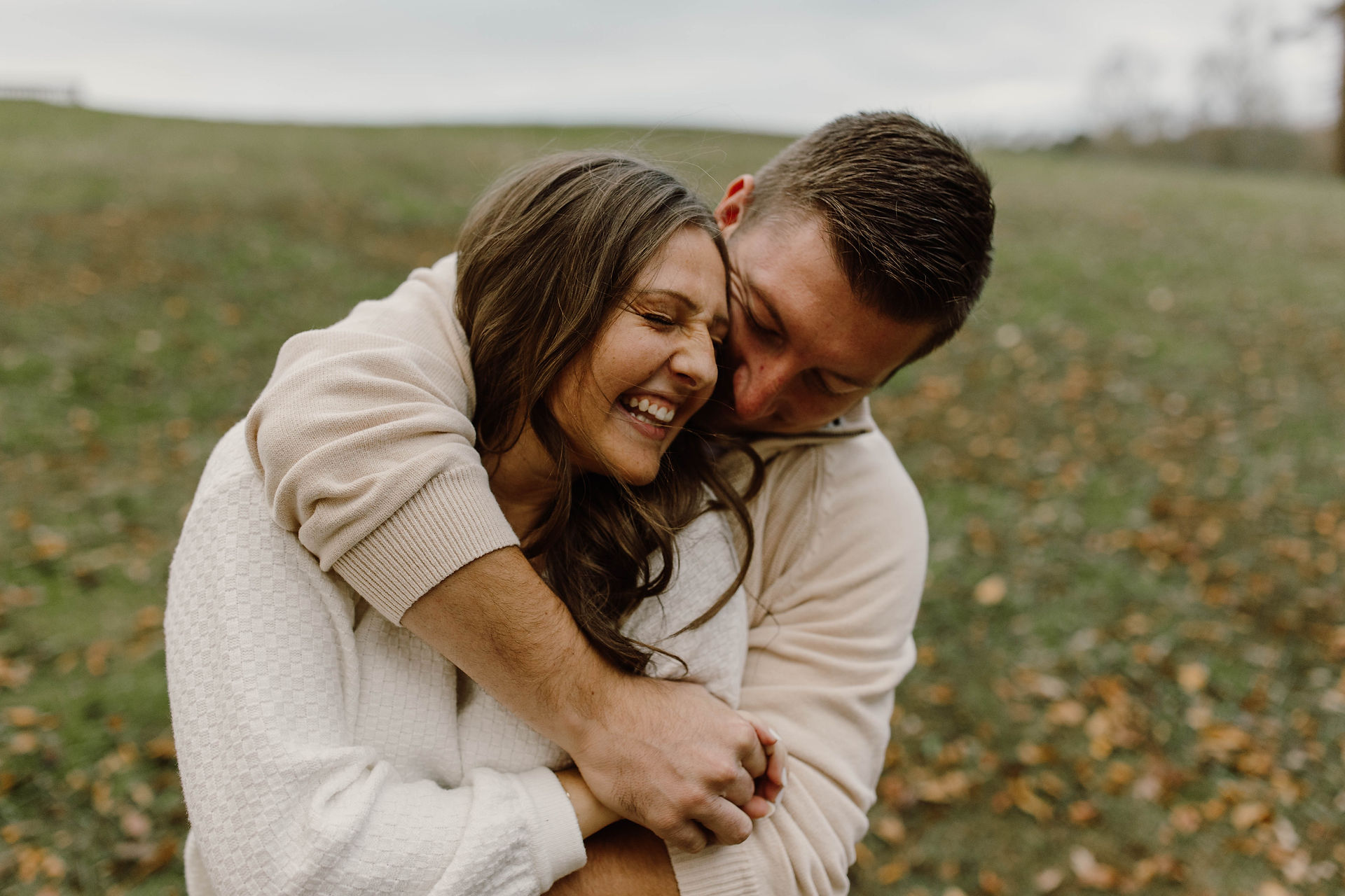 A photo of a couple with his arms wrapped around her