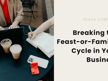 A table with coffee, a phone, a camera, and a laptop. On the right of the image, the text states " Skapa Company Breaking the Feast-or-Famine Cycle in Your Business"