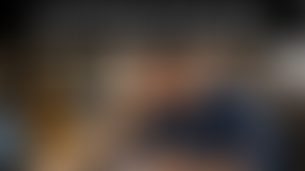 Manufacturing business owner seated at a desk on a factory floor, reviewing a cash flow report with a focused, concerned expression. A laptop with financial charts, calculator, cash, hard hat, and coffee cup sit on the table, with warehouse equipment and machinery blurred in the background. Bold text above reads, “Cash Flow Is a Leadership Issue, Not Just a Finance Problem.