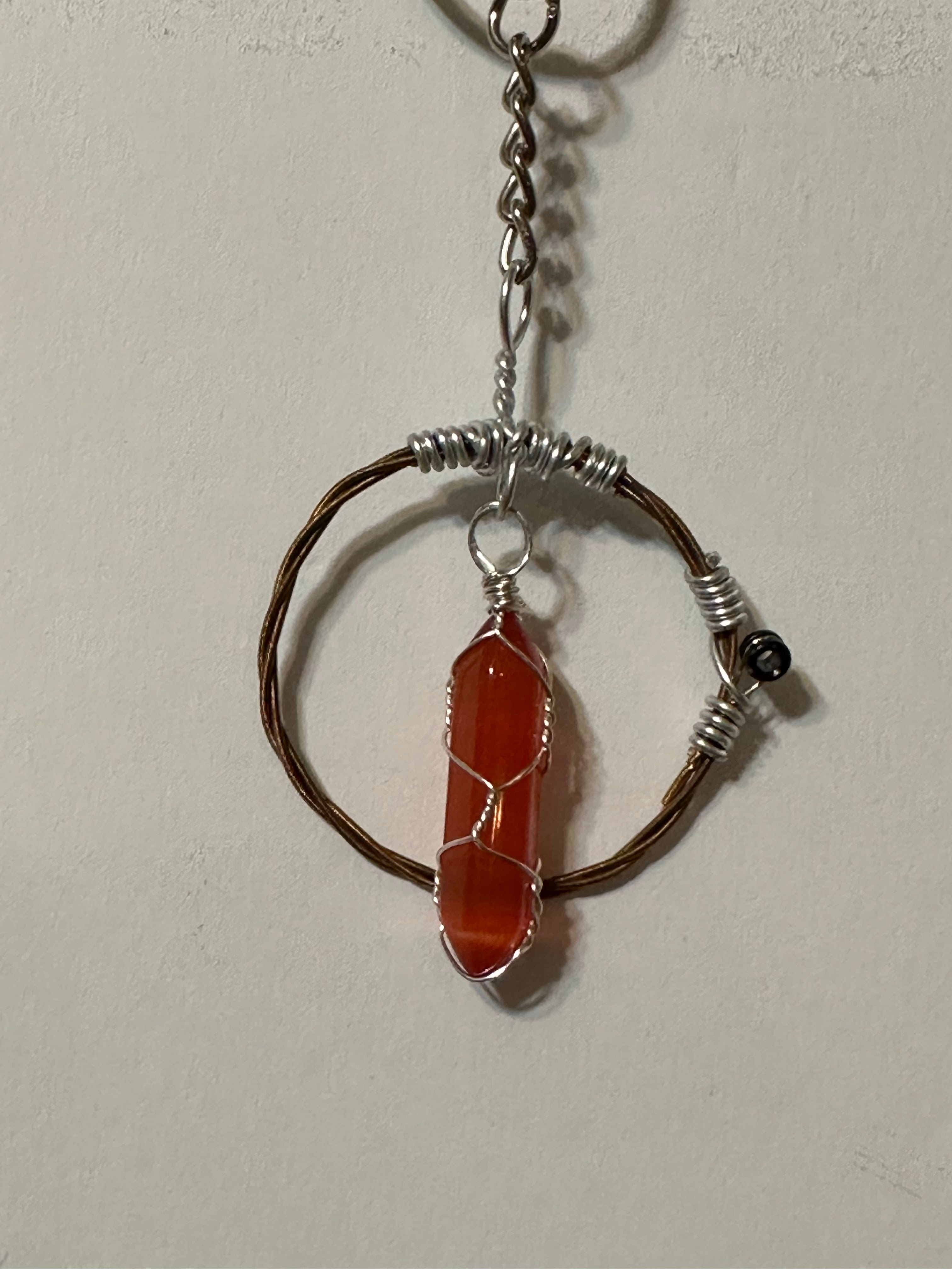 Carnelian agate crystal in guitar string circle of love.