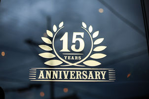 Banana Blossom 15 year anniversary logo in gold print on a glass door.
