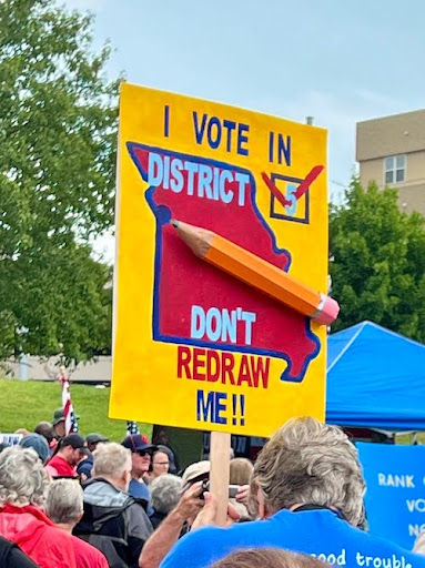 Protesters rally against gerrymandering, holding a sign urging to keep district boundaries unchanged.